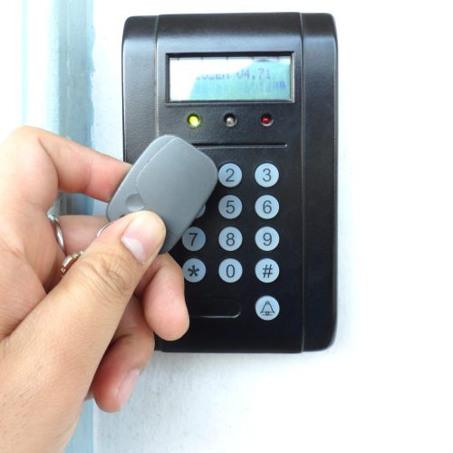 Door access control with a hand inserting key card to lock and unlock door. Security system concept.