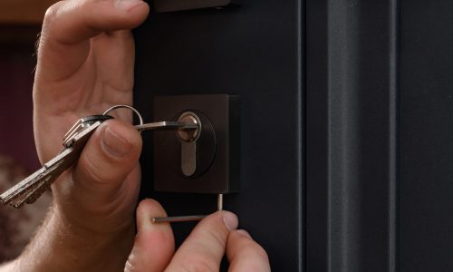 Installation of a door lock, a carpenter installs a door lock in a door, close-up work, fixing the core of the lock.